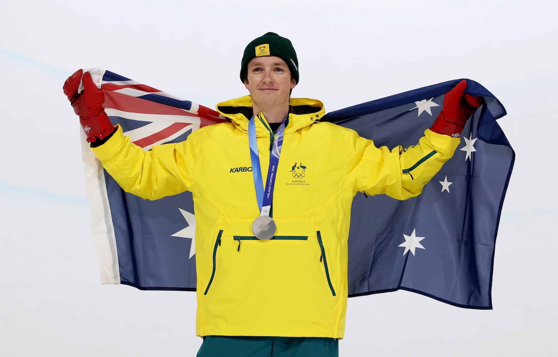 LIVIGNO, ITALY - FEBRUARY 13: Silver medalist Scotty James of Team Australia poses for a photo whilst holding the national flag of Australia during the medal ceremony for the Men's Snowboard Halfpipe on day seven of the Milano Cortina 2026 Winter Olympic games at Livigno Snow Park on February 13, 2026 in Livigno, Italy. (Photo by Patrick Smith/Getty Images)
