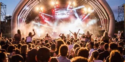 Girls on shoulders in the crowd at Party In the Park with it's inflatable stage