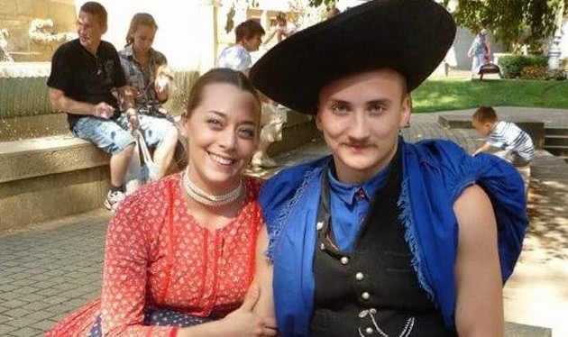 Couple at Hungarian Cultural Festival sit in a park wearing folk dress of Hungary