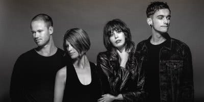 Four band members of The Jezabels, all wearing black , shot in a studio in black and white