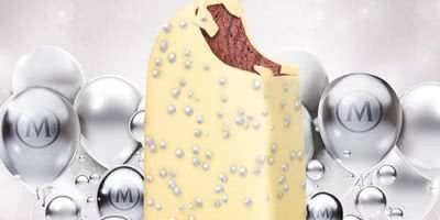 White chocolate and silver balls covering a Red Velvet Magnum on a background of silver Magnum balloons