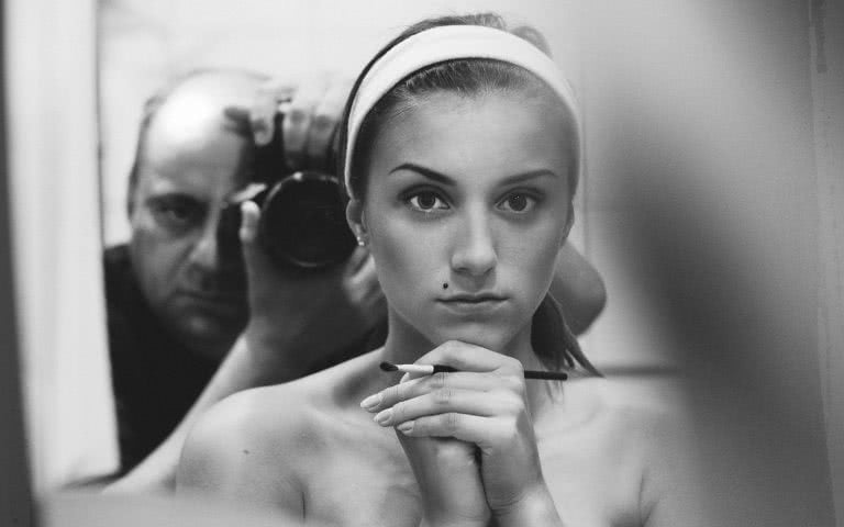 Photographer Kozlovskiy taking a black-and-white art portrait of Russian nude in a mirror