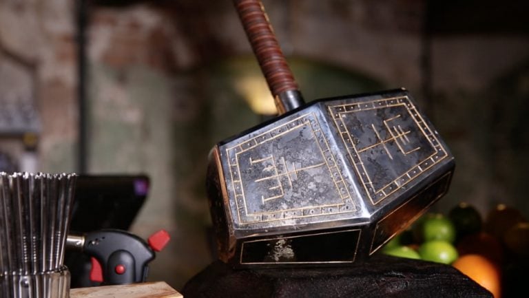 Thor's hammer, engraved with Scandinavian symbols, sits on a bar