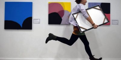 A young woman rushes out of a gallery with a stolen painting under her arm.