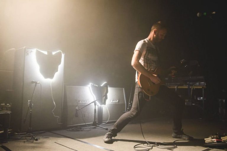 Luca Brasi guitarist Patrick Marshall playing the Metro Theatre, with fluorescent maps of Tasmania lighting the band's amps.