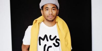 Toro y Moi AKA Chaz Bundick stands wearing a Music T-shirt and beanie