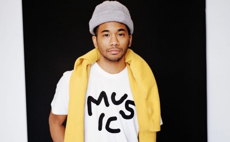 Toro y Moi AKA Chaz Bundick stands wearing a Music T-shirt and beanie