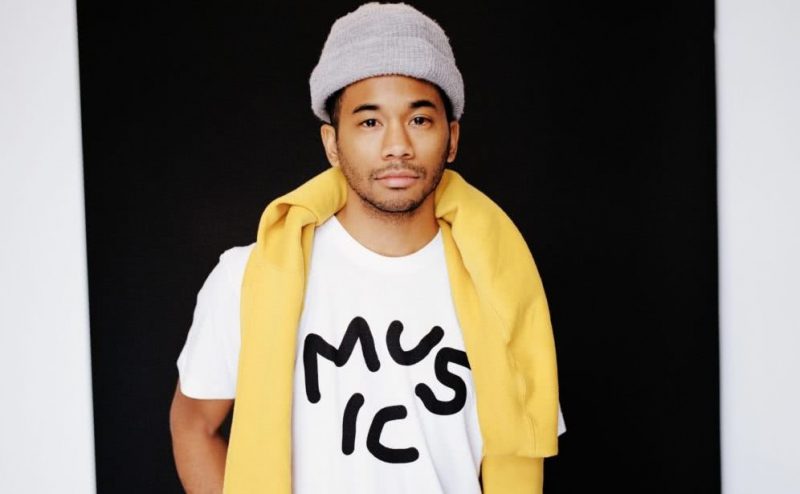 Toro y Moi AKA Chaz Bundick stands wearing a Music T-shirt and beanie