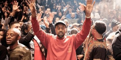 Kanye West raising his hands in front of a crowd