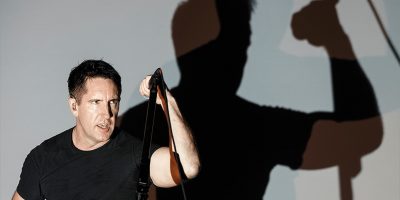 Nine Inch Nails' Trent Reznor playing live, with his shadow behind him