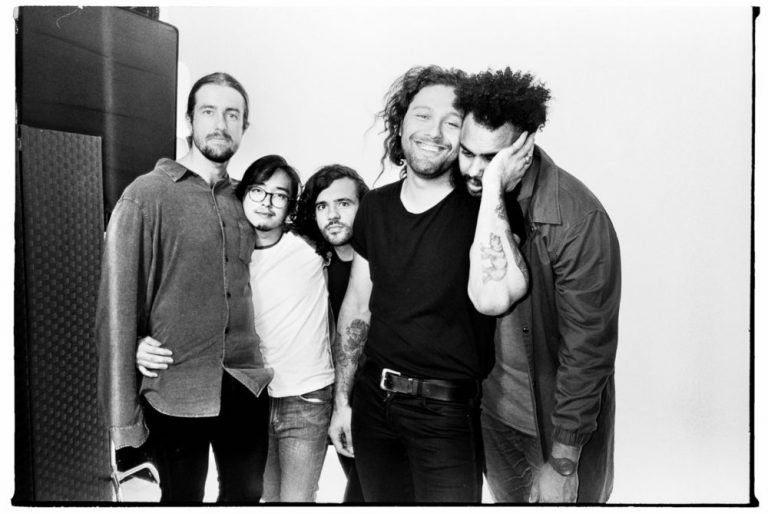 Gang Of Youths share an embrace in tasteful black and white.