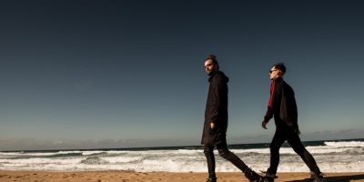 Boo Seeka producer Sammy Seeka and vocalist Boo walking across a beach