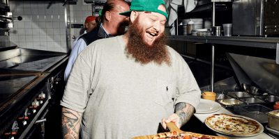 Action Bronson laughs as he cooks a pizza