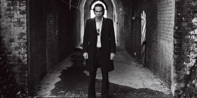 Nick Cave stares out from a dark corridor