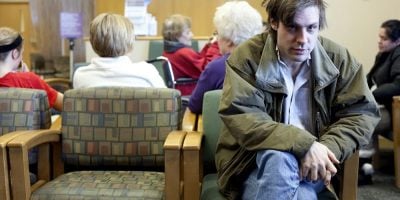 John Maus sitting in a waiting room