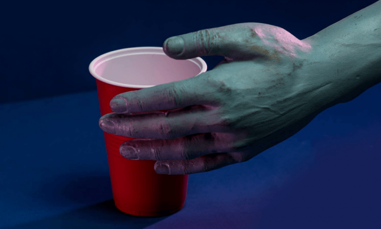 A zombie hand reaches for a red plastic cup