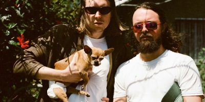 Alex Cameron with a dog in a backyard