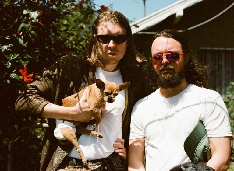 Alex Cameron with a dog in a backyard