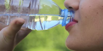 Image of a female drinking a bottle of water