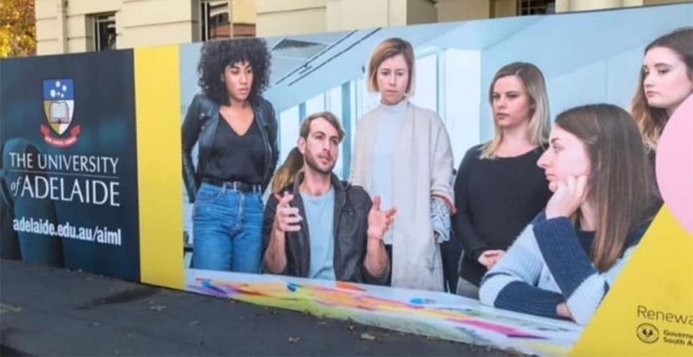 Ad outside the old Royal Adelaide Hospital site with the Adelaide University logo visible on the left