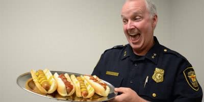 Image of a US police officer with hot dogs