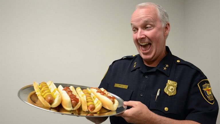 Image of a US police officer with hot dogs