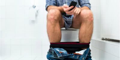 Image-man-using-phone-on-toilet