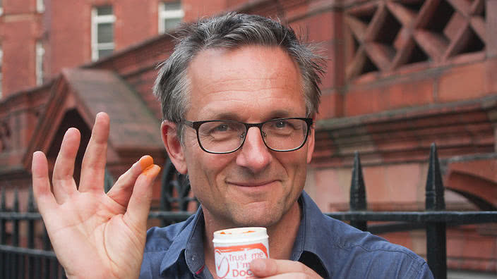 Dr Michael Mosley holding orange powder