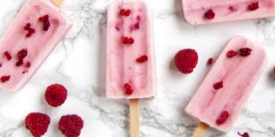 Raspberry popsicles on a white marble background