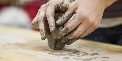 Someone moulding clay into pottery