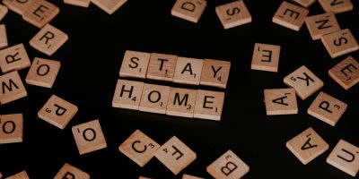 Scrabble tiles spelling out 'Stay Home'