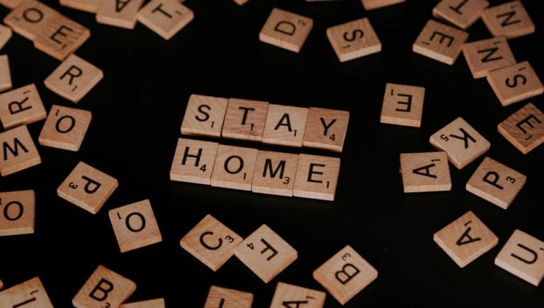 Scrabble tiles spelling out 'Stay Home'