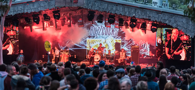 Crowd standing infant of stage watching a band perform