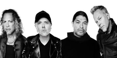 Metallica band members wearing black clothes standing in front of a white background