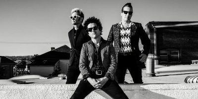 Black and white image of Green Day band members wearing sunglasses looking at camera