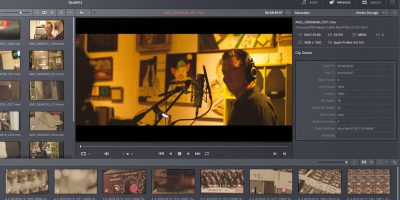 Screenshot of video editing man with headphones on in from of microphone