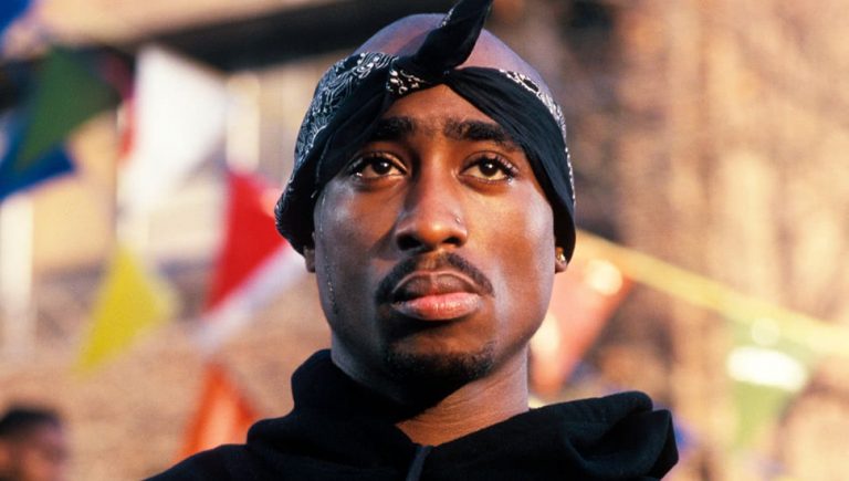 Close up of Tupac wearing a black jumper and a black bandana tied around his head