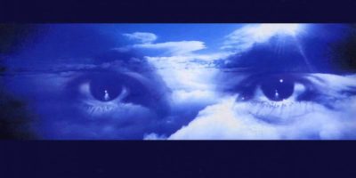 Robert Miles' eyes floating through blue and white clouds.