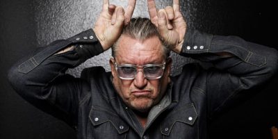 Sex Pistols' Steve Jones giving a double-handed 'devil horns' salute