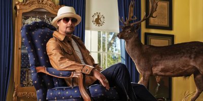 US musician Kid Rock lounging by a stuffed deer