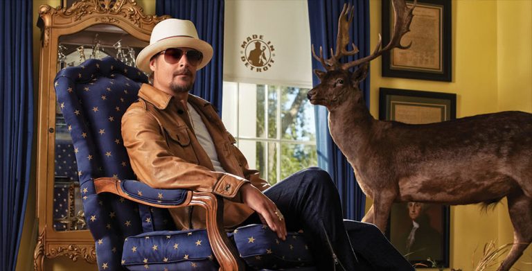 US musician Kid Rock lounging by a stuffed deer