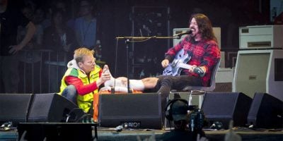 Dave Grohl being attended to by a medic after breaking his leg