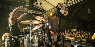 The Living End's Chris Cheney leaps in the air onstage