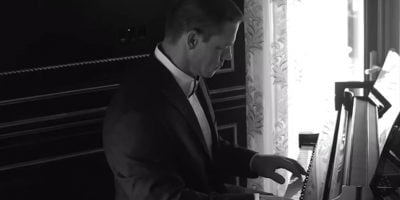 Wrestling legend John Cena playing the piano in a tuxedo
