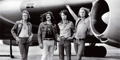 Led Zeppelin standing in front of their famous Starship