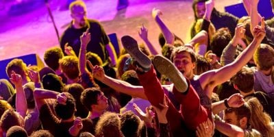 A punter crowd-surfs in a mosh pit