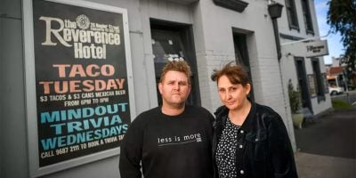 The Reverence Hotel owners Matt Bodiam and partner Melanie in front of a 'Taco Tuesday' sign