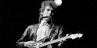 Bob Dylan performing on an electric guitar at the 1965 Newport Folk Festival
