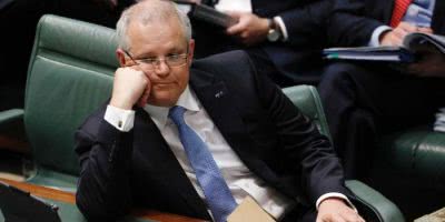 scott morrison leaning against desk