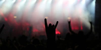 Image of a fan doing devil horns at a heavy metal concert